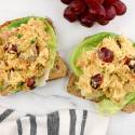 Curry tuna salad on whole wheat toast with lettuce and red grapes.