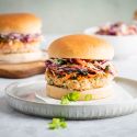 Salmon burgers with fresh salmon and spices served on a bun with coleslaw.