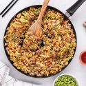 Egg roll in a bowl with ground chicken, shredded cabbage, and an Asian sauce.