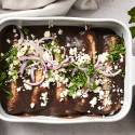 Enfrijoladas with chicken and black bean sauce in a pan ready to be served.