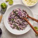 Fish taco slaw in a bowl with shredded cabbage, cilantro, lime juice, and green onions in a bowl.