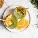 Green smoothie without bananas in a glass with chia seeds and mango on tops.