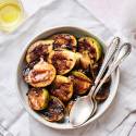 Grilled figs with balsamic glaze served in a bowl with two spoons.
