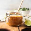 Habanero salsa made with roasted habanero peppers, garlic, citrus juice, and tomatoes in a small glass jar.