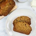 Healthy Cinnamon Banana Bread sliced on a plate with the whole loaf on the side.