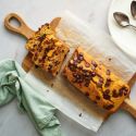Healthy pumpkin chocolate chip bread sliced and served on a wooden cutting board.