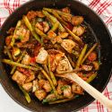 Italian chicken and vegetable skillet in a pan with chicken breast, asparagus, zucchini, parsley, and fresh lemon.