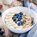 Blueberry chia seed pudding served in a bowl with fresh blueberries and sliced bananas on top.