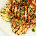 Grilled pineapple chicken with barbecue sauce and grilled pineapple rings.