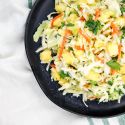 Pineapple coleslaw with carrots, pineapple, cabbage, cilantro, and coconut dressing in a bowl.