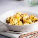 Roasted cauliflower with crispy browned edges in a white bowl.