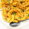 Roasted delicata squash with brown sugar and cinnmon on a white plate.