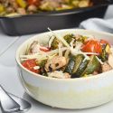 Italian chicken and vegetables in a bowl with Parmesan cheese.