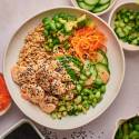 Sushi bowls with spicy shrimp, avocado, cucumbers, carrots, and edamame with brown rice.