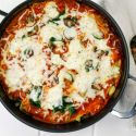 Skillet vegetable lasagna in a pan with zucchini, spinach, mushrooms, and melted cheese.
