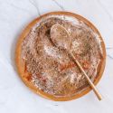 Steak seasoning with kosher salt, pepper, paprika, garlic powder, onion powder, and herbs on a wooden plate.