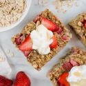 Strawberry banana baked oatmeal cut into sqaures with yogurt and honey on top.