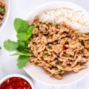 Thai Chicken Larb with fresh mint and basil in a white bowl with cauliflower rice.
