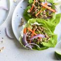 Thai turkey lettuce wraps with butter lettuce, ground turkey, carrots, cilantro, and chopped peanuts.