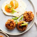 Turkey breakfast sausage served on a plate with sunny side ip eggs and green onions.