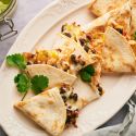 Turkey quesadillas with shredded turkey, black beans, peppers, and cheese cooked in flour tortillas with cilantro and salsa.