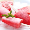 Two watermelon popsicles with a block of ice.