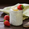 Yogurt chia seed pudding in a glass with a fresh blackberry.