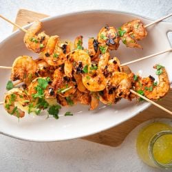 Garlic grilled shrimp on wooden skewers with spices, lemon juice, and melted butter.