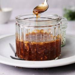 Homemade teriyaki sauce in a jar with a spoon.