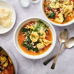 Spinach tortellini soup in a bowl with ground turkey, spinach, white beans, and tomatoes in a white bowl.