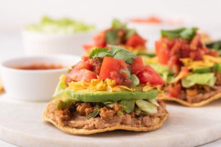 Ground turkey tostadas with beans, ground turkey, avocado, tomatoes, cheese, and cilantro.