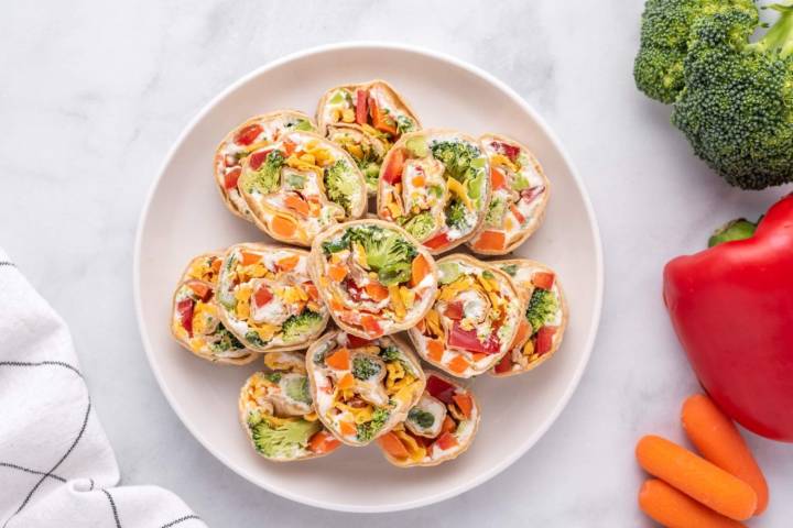 Healthy cream cheese pinwheels with vegetables served on a white plate/