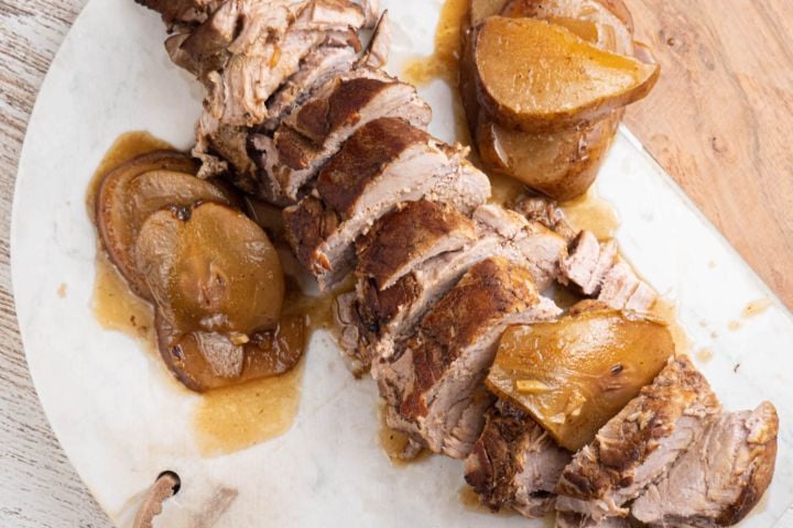 Slow cooker balsamic honey pork tenderloin with cooked pears on a plate.