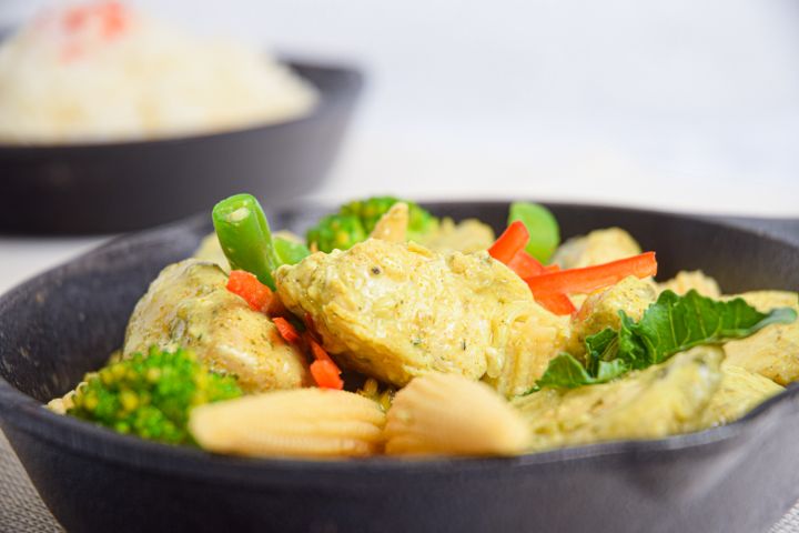 Slow Cooker Thai Curry Chicken with vegetables and curry sauce in a bowl with rice.