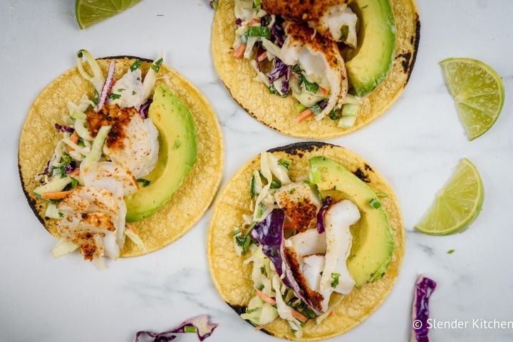 Fish tacos with lime coleslaw on corn tortillas with avocado.