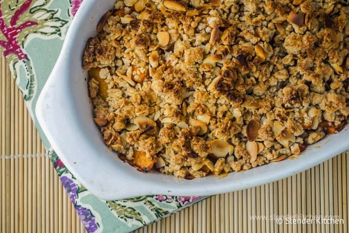 Apricot crumble with a crispy baked topping in a ceramic dish.
