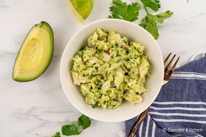 Avocado chicken salad with shredded chicken breast, avocados, lime juice, and cilantro in a bowl.