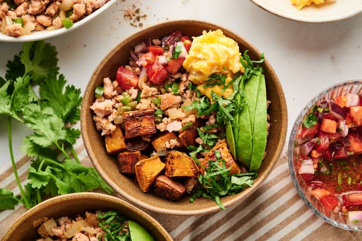 Breakfast burrito bowls with ground turkey, scrambled eggs, roasted sweet potatoes, avocado, pico de gallo, and cilantro.