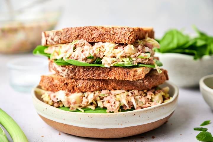 Cabbage tuna salad with canned tuna, yogurt, shredded cabbage, and green onions served on wheat bread.