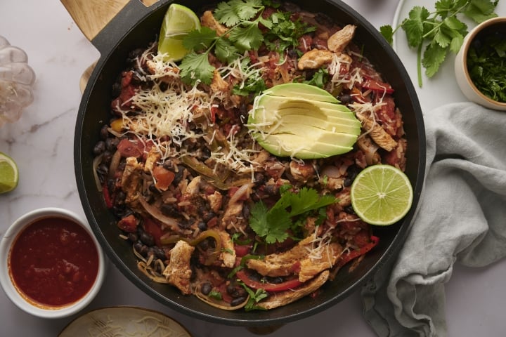 Mexican chicken and rice with chicken breast, peppers tomatoes, black bean, rice topped with avocado and cilantro.