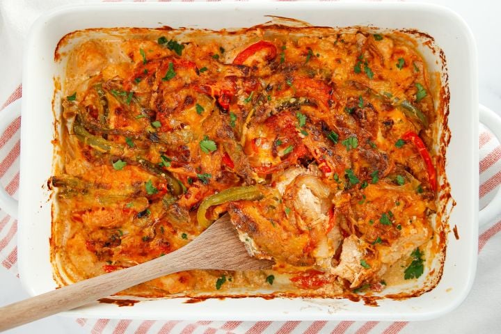 Chicken fajita casserole baked in a dish with peppers, onions, chicken breast, and melted cheese.