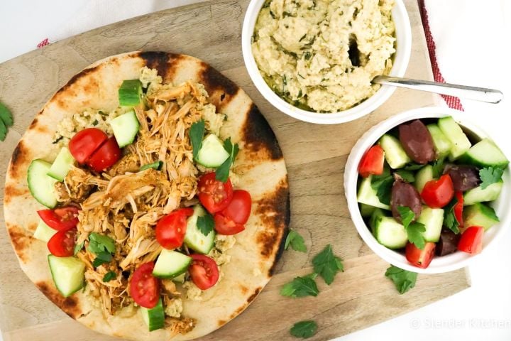 Chicken shawarma on a pita with Israeli salad and hummus on the side.