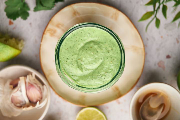 Cilantro lime sauce made with Greek yogurt, cilantro, garlic, lime juice, and spices in a glass jar. 