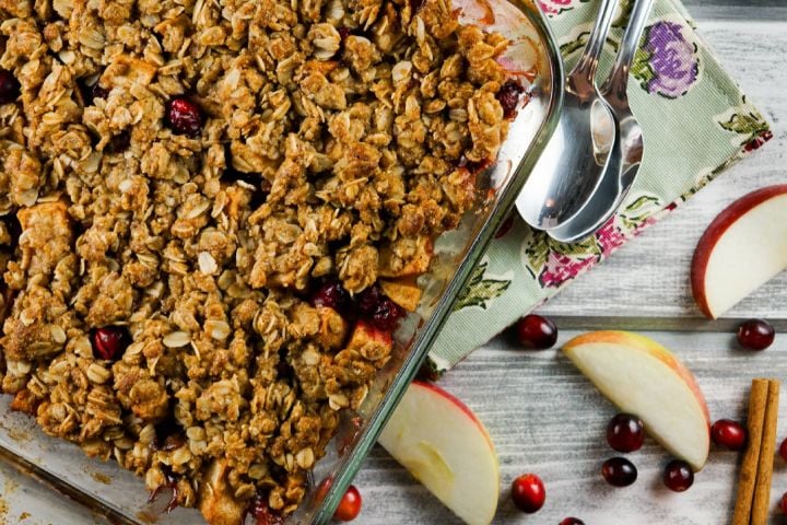 Cranberry Apple Baked Oatmeal with apple slices and fresh cranberries next to the dish.