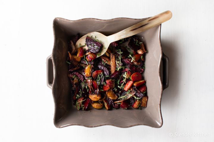Easy roasted beets with balsamic vinegar and honey in a dish with fresh herbs.