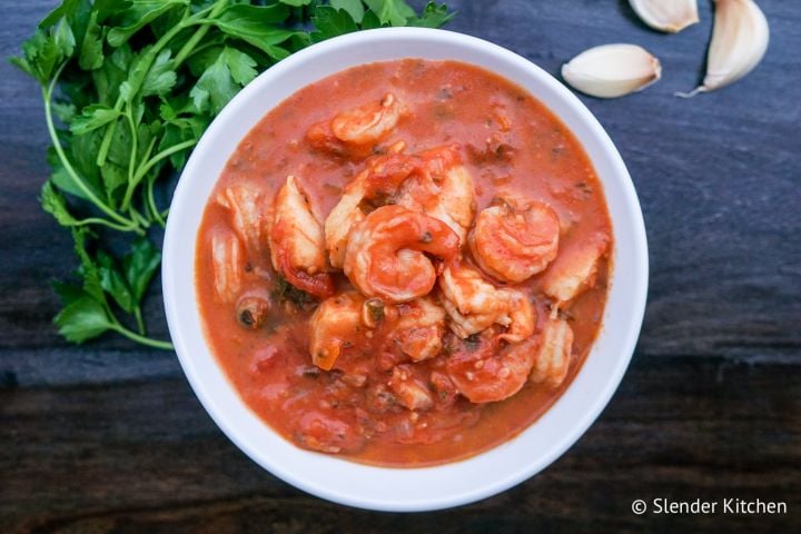 Fish and shrimp stew in a bowl with a tomato and garlic broth.