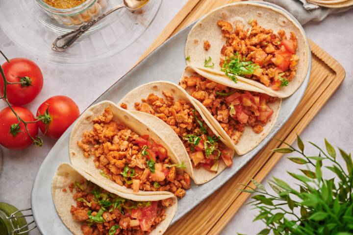Ground chicken tacos with seasoned ground chicken, tomatoes, and lettuce in flour tortillas.