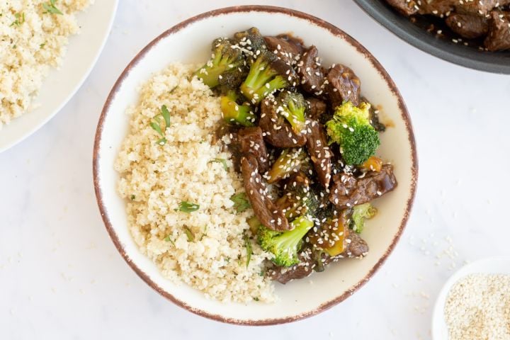 Healthy beef and broccoli served on a plate with steamed rice.