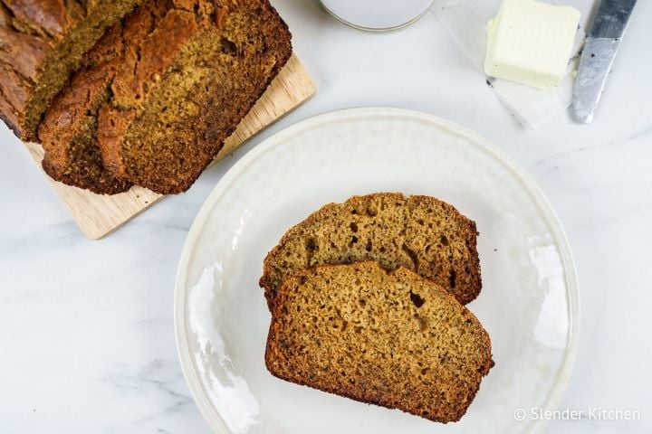 Healthy Cinnamon Banana Bread sliced on a plate with the whole loaf on the side.