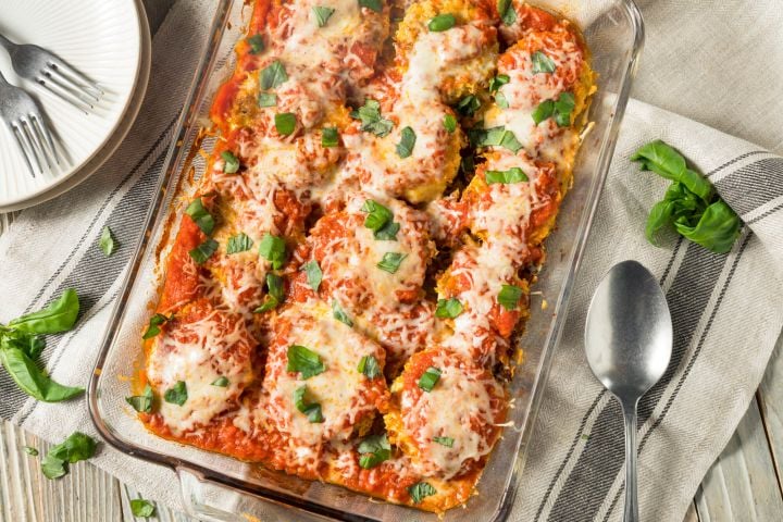 Healthy Eggplant Parmesan in a casserole dish with tomato sauce and melted cheese.